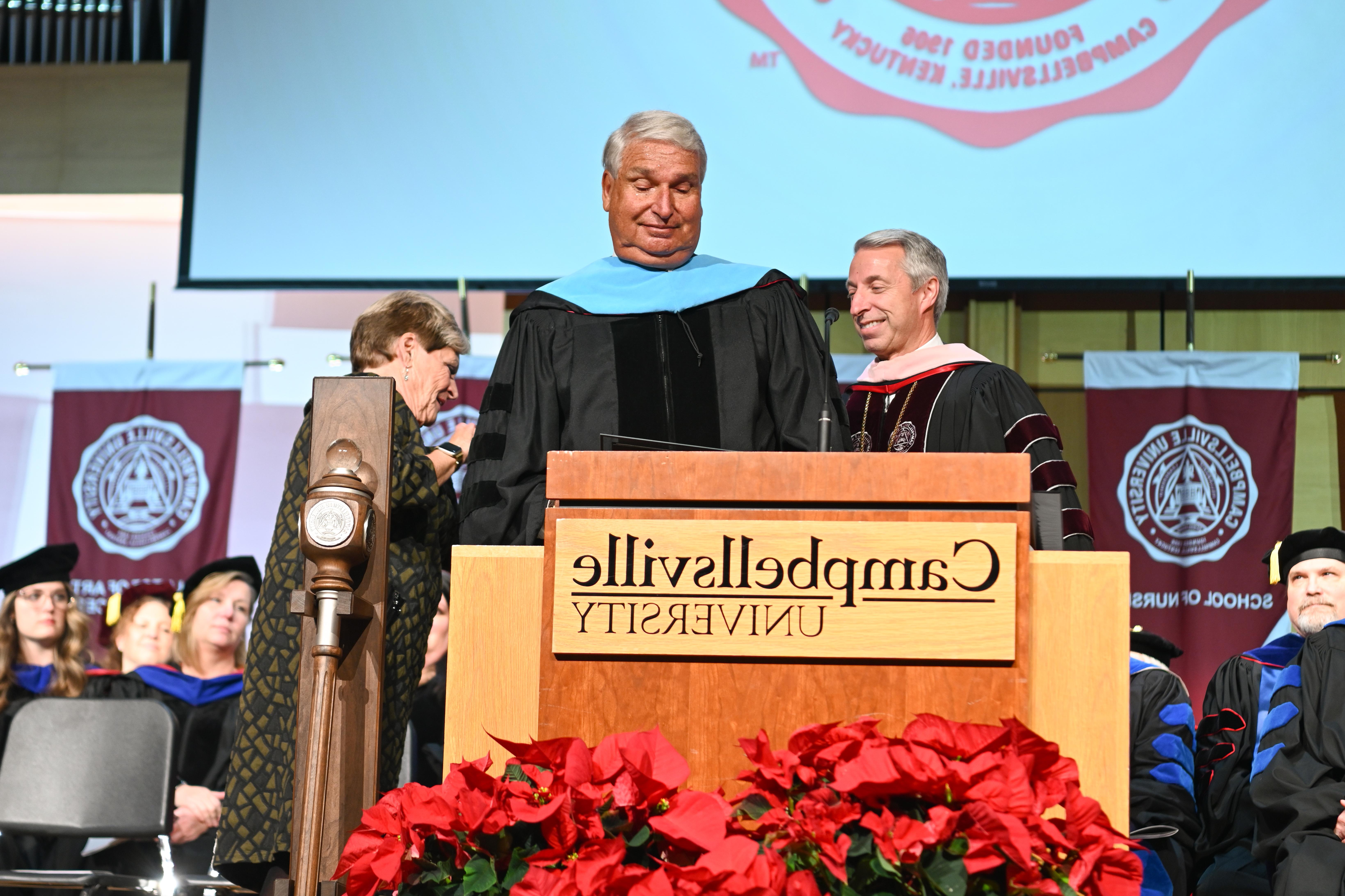 Three people standing behind a podium.